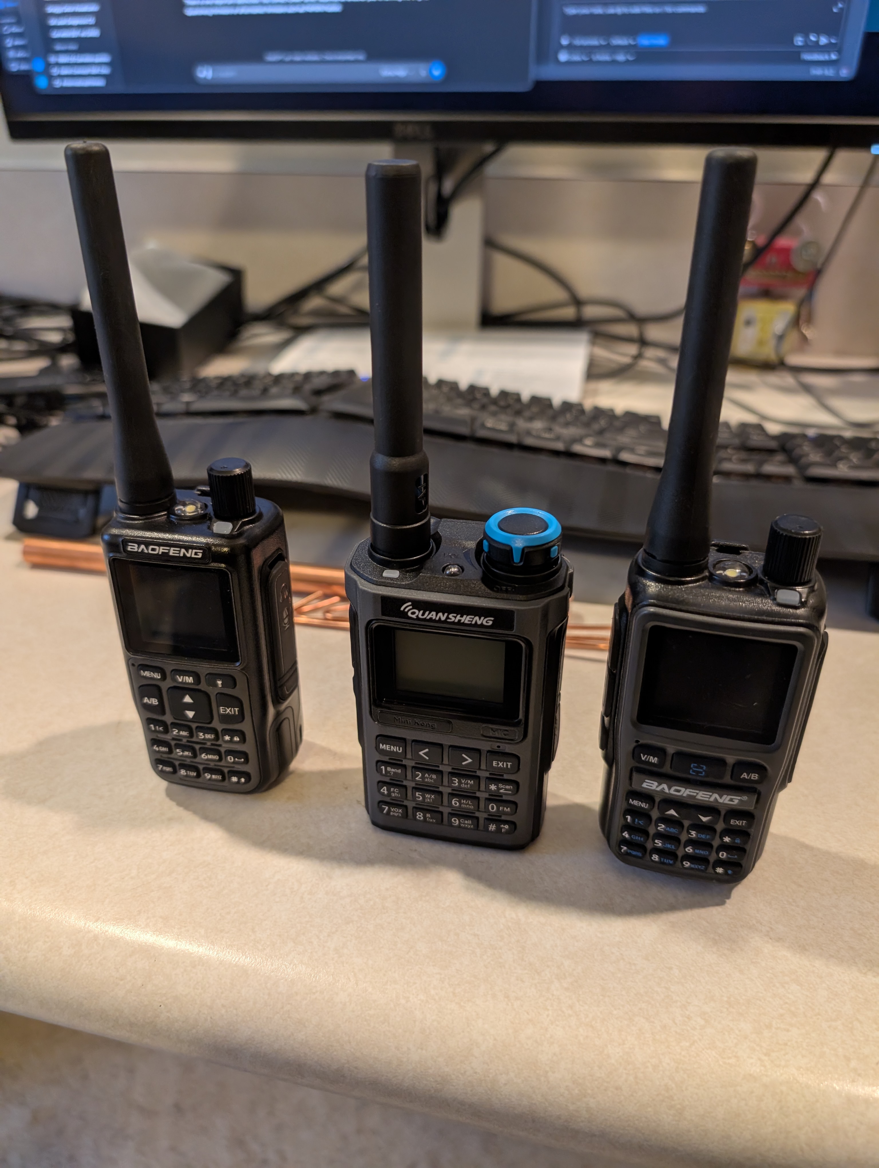 Left to right, a Baofeng UV-Mini5, a Quansheng K1, and a Baofeng UV-5R mini