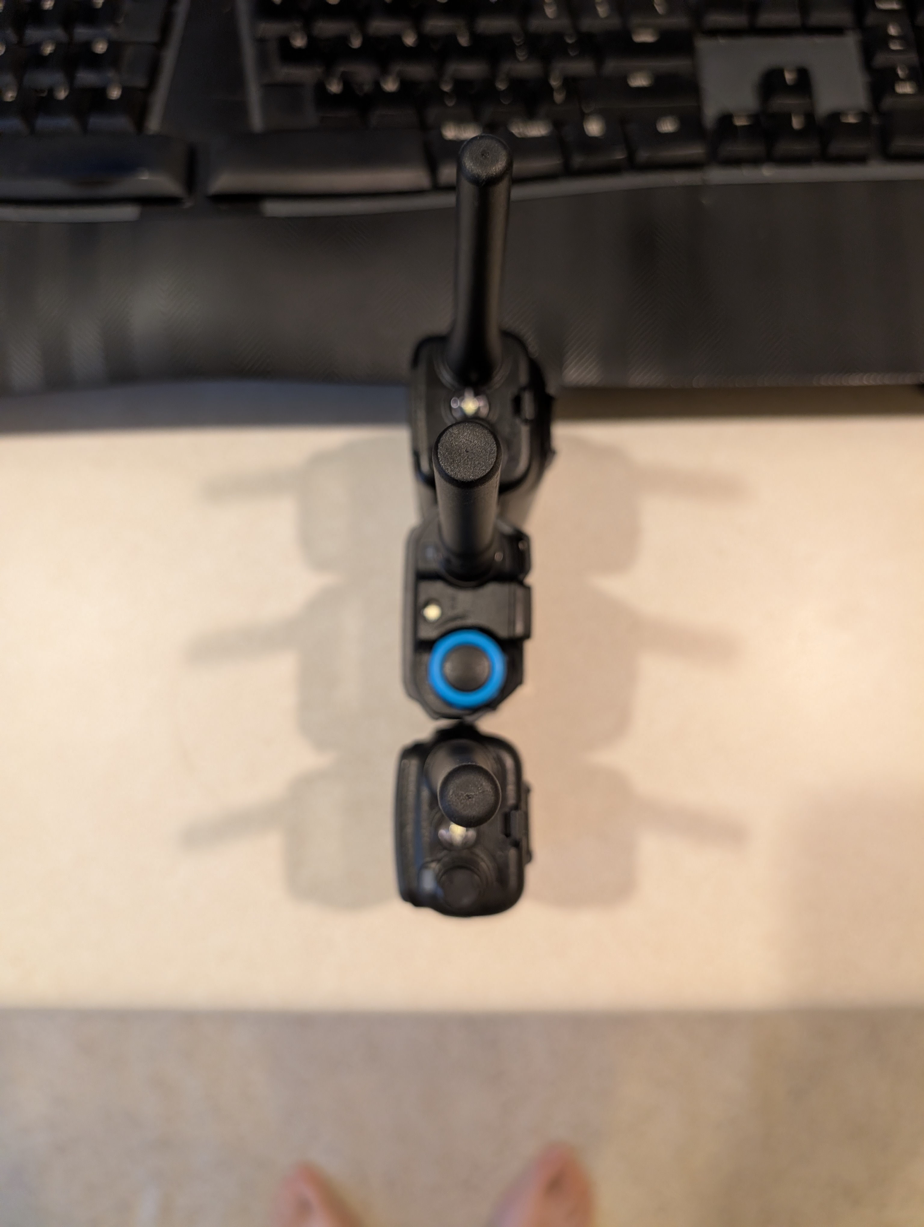 Overhead view of the following radios, organized top to bottom: Baofeng UV-mini 5, Quansheng UV-k1, and Baofeng UV-5R mini. The UV-k1 sits comfortably between the two radios size wise.